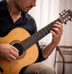 Klasik gitar çalan bir erkeğin ellerinin yakın çekimi